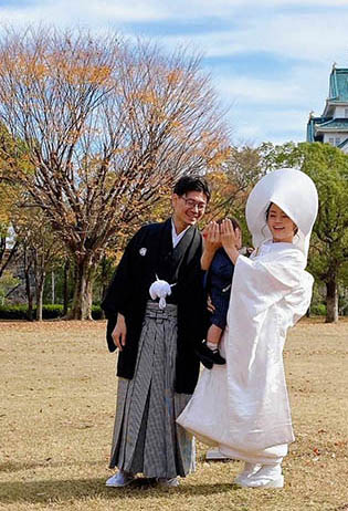 Japanskt bröllopspar han i svart och hon i ljus kimono