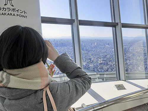 Kvinna filmar utsikten över Tokyo från Skytree